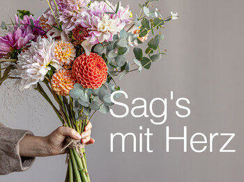 Eine Hand überreicht einen Blumenstrauß zum Muttertag
