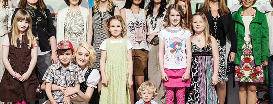 carla Modeschau: Ein Gruppenfoto zeigt alle Models, die an der Modeschau teilgenommen haben. In der ersten Reihe stehen dabei die Kinder. 