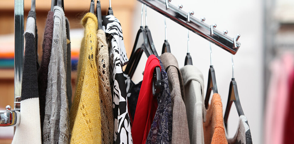 Wolljacken unterschiedlicher Farben hängen an einem Kleiderständer. 